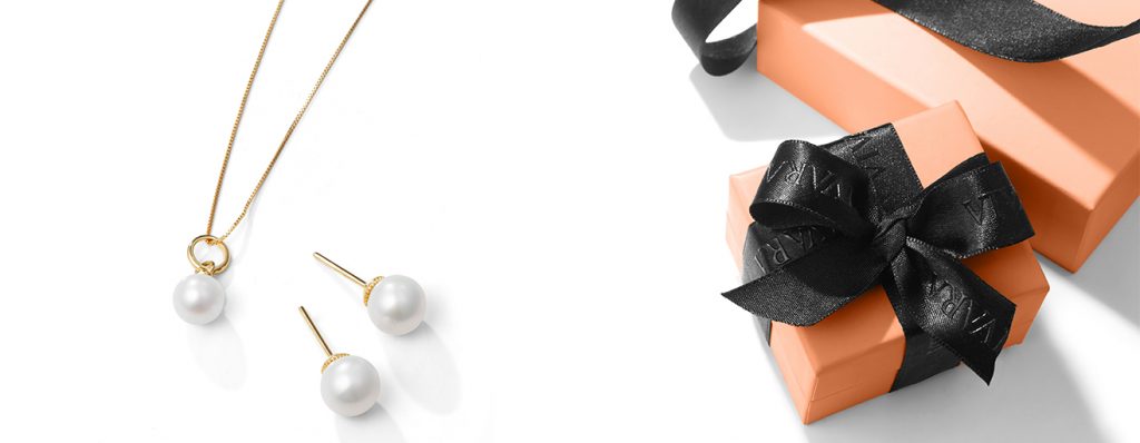Caixas de presente vivara ao lado de joias minimalistas, colar minimalista e brincos minimalista.